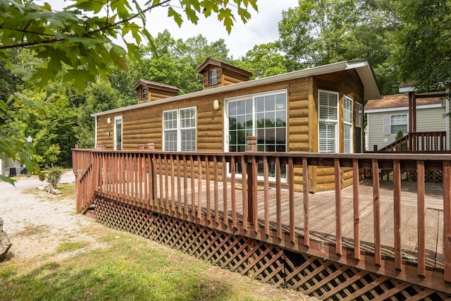 rear view of house featuring a wooden deck and log veneer siding