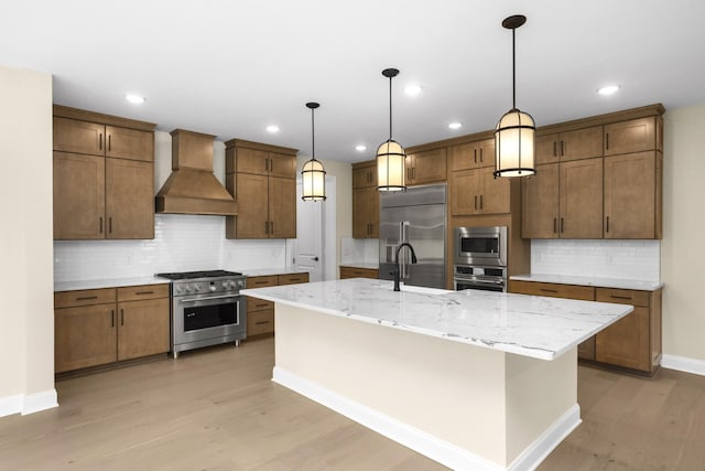 5958 Hunt Valley Dr, Spring Hill, TN 37174 - kitchen with built in appliances, custom exhaust hood, decorative backsplash, light wood-type flooring, and a kitchen island with sink