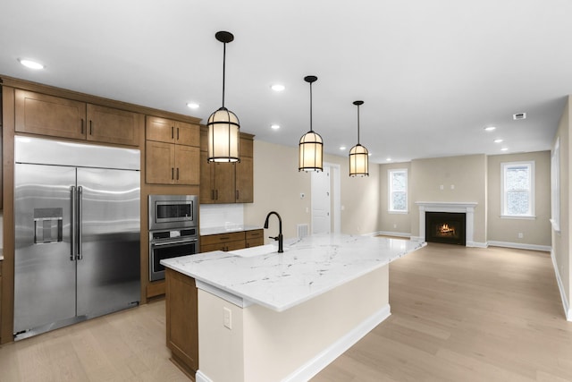 5958 Hunt Valley Dr, Spring Hill, TN 37174 - kitchen featuring built in appliances, light wood-style floors, recessed lighting, light stone counters, and decorative light fixtures