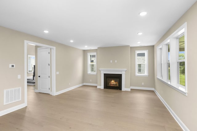 5958 Hunt Valley Dr, Spring Hill, TN 37174 - unfurnished living room featuring light wood-style flooring, a glass covered fireplace, and recessed lighting
