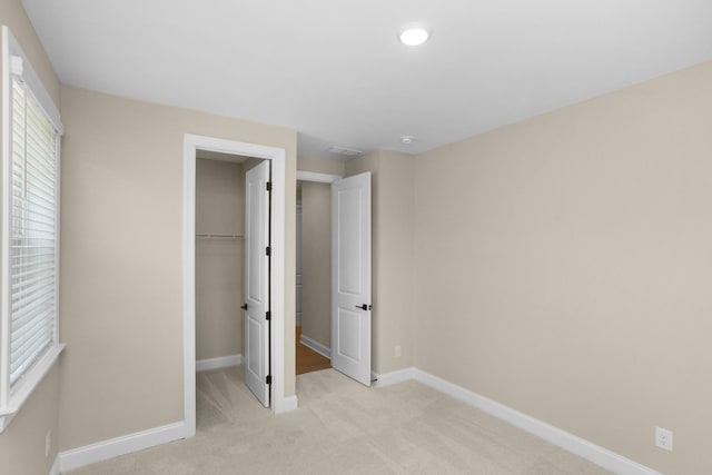 5958 Hunt Valley Dr, Spring Hill, TN 37174 - unfurnished bedroom with light carpet, a walk in closet, and a closet