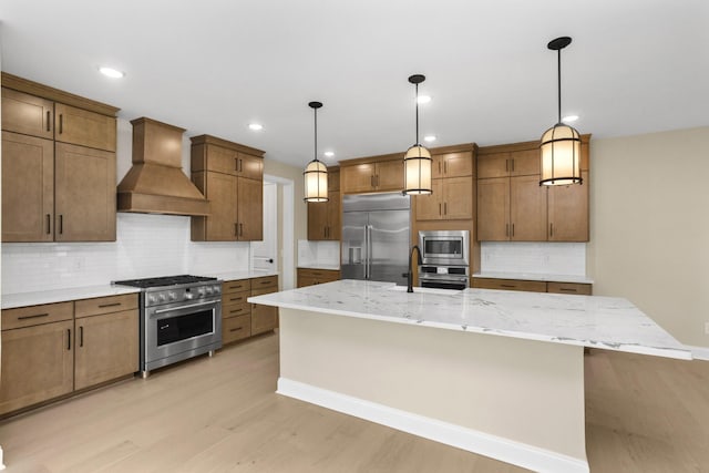 5958 Hunt Valley Dr, Spring Hill, TN 37174 - kitchen featuring premium range hood, built in appliances, decorative backsplash, light wood-type flooring, and a center island with sink