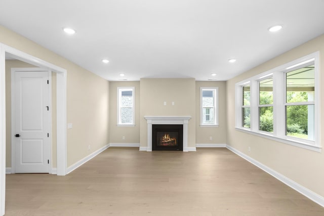 5958 Hunt Valley Dr, Spring Hill, TN 37174 - unfurnished living room with light wood-style floors, healthy amount of natural light, a glass covered fireplace, and recessed lighting