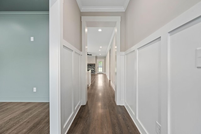 hall with ornamental molding and dark wood-style floors