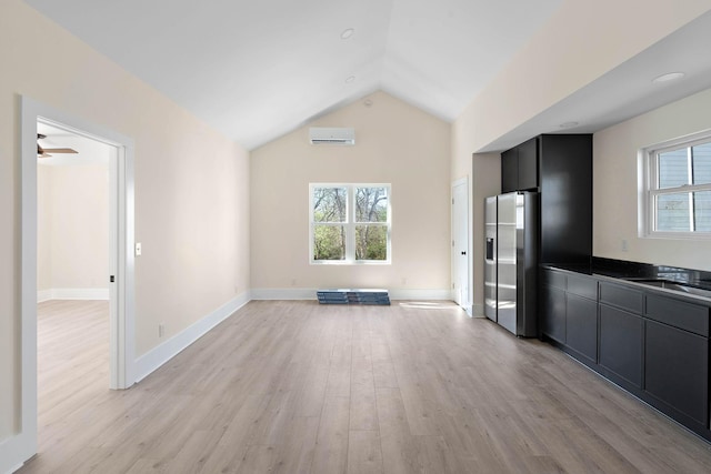 736 Douglas Ave, Nashville, TN 37207 - unfurnished living room featuring light wood-type flooring, vaulted ceiling, ceiling fan, a wall mounted AC, and baseboards