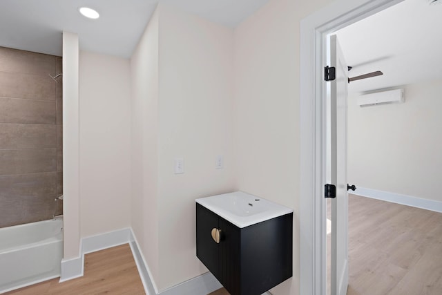 736 Douglas Ave, Nashville, TN 37207 - bathroom with wood finished floors, vanity, an AC wall unit, shower / bath combination, and baseboards