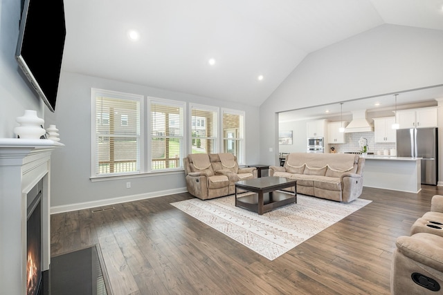 5509 Dana Ln, Franklin, TN 37064 - living area featuring a lit fireplace, dark wood-style flooring, recessed lighting, high vaulted ceiling, and baseboards
