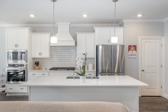 5509 Dana Ln, Franklin, TN 37064 - kitchen featuring stainless steel appliances, custom exhaust hood, dark wood finished floors, an island with sink, and white cabinetry