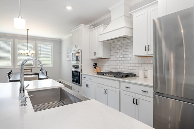 5509 Dana Ln, Franklin, TN 37064 - kitchen with stainless steel appliances, premium range hood, a sink, ornamental molding, and a chandelier