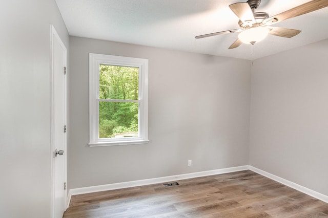 spare room with baseboards, a ceiling fan, and wood finished floors