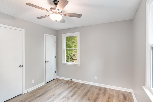 unfurnished bedroom featuring light wood finished floors, baseboards, and a ceiling fan