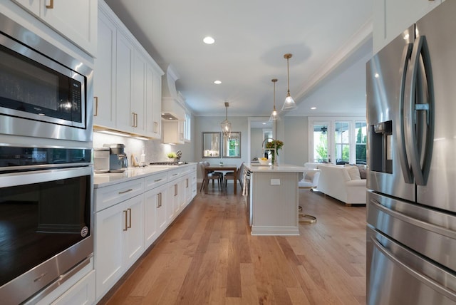 kitchen with recessed lighting, white cabinetry, open floor plan, light countertops, and appliances with stainless steel finishes