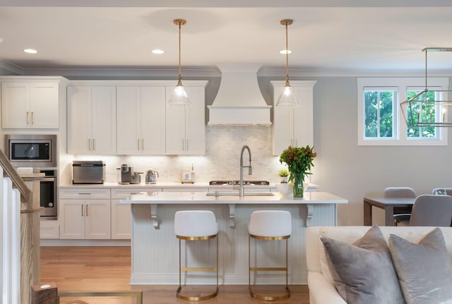 kitchen featuring light countertops, appliances with stainless steel finishes, premium range hood, and tasteful backsplash