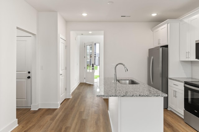kitchen featuring a sink, stainless steel appliances, wood finished floors, and white cabinets