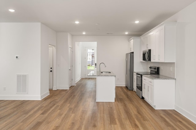 kitchen with a sink, visible vents, a center island with sink, white cabinets, and appliances with stainless steel finishes