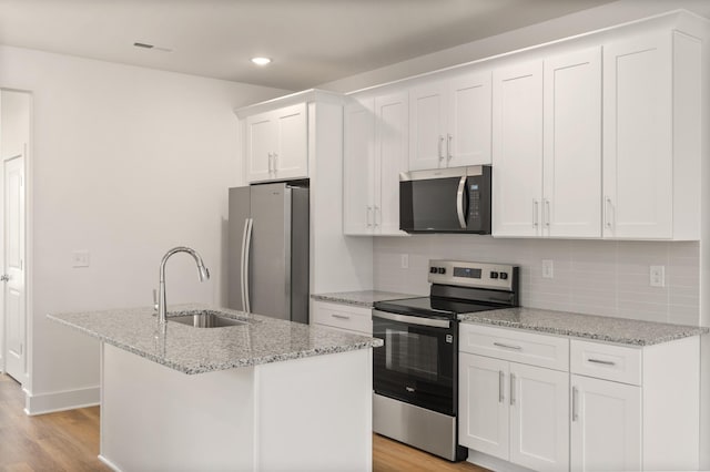 kitchen featuring a sink, light wood finished floors, stainless steel appliances, and white cabinetry