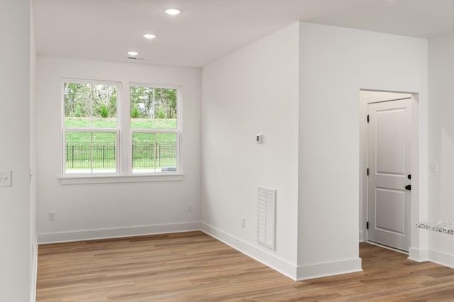 unfurnished room with light wood finished floors, baseboards, visible vents, and recessed lighting