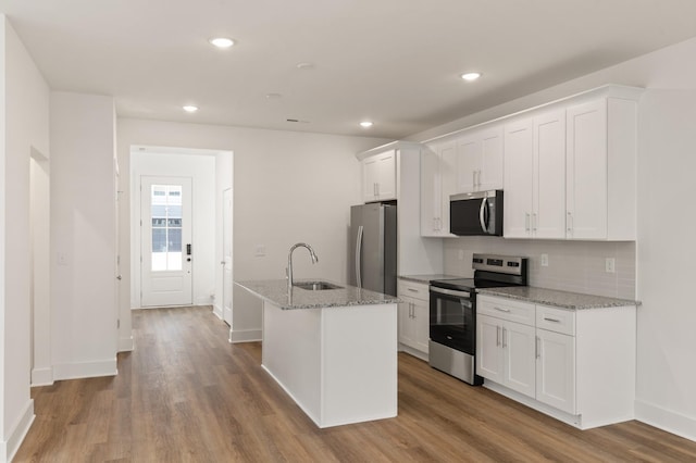 kitchen featuring white cabinets, appliances with stainless steel finishes, a sink, and wood finished floors