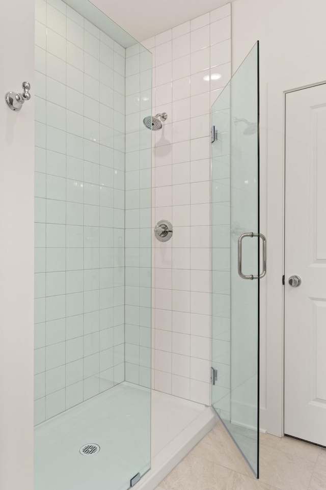 full bath with tile patterned flooring and a shower stall