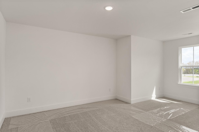 unfurnished room with light carpet, baseboards, and visible vents