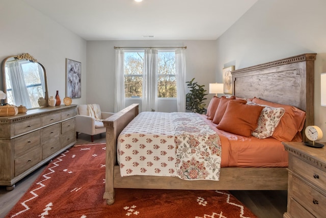 bedroom featuring visible vents and dark wood finished floors
