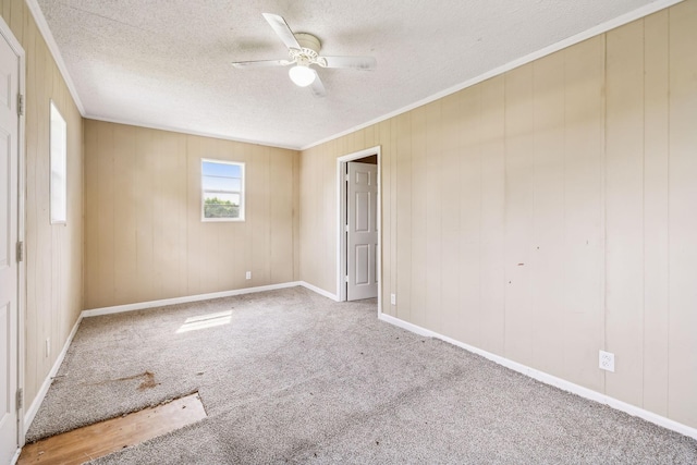 unfurnished room featuring carpet flooring, a textured ceiling, ceiling fan, and ornamental molding