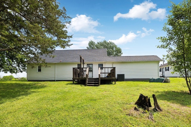 back of property with a deck, central AC, and a lawn