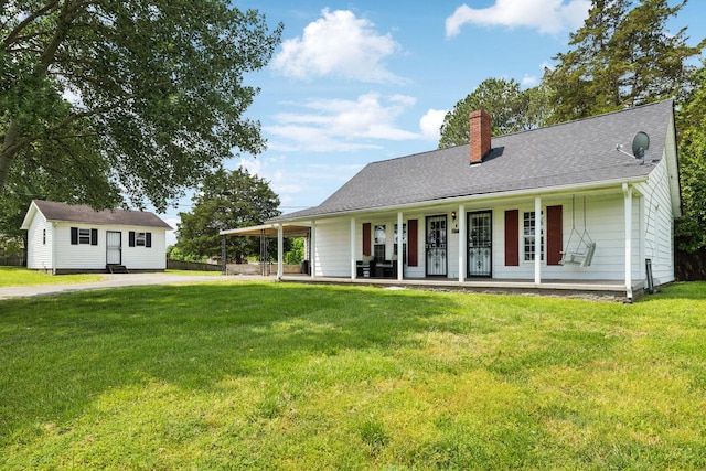 view of front facade with a chimney, driveway, a front lawn, and covered porch