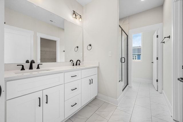 full bath with a sink, a shower stall, and marble finish floor