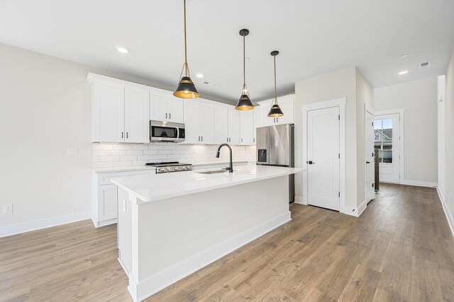 10114 Bighorn Ln, Bell Buckle, TN 37020 - kitchen with a sink, decorative backsplash, light countertops, a kitchen island with sink, and appliances with stainless steel finishes