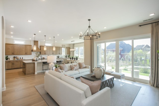 living area with a chandelier, plenty of natural light, and recessed lighting