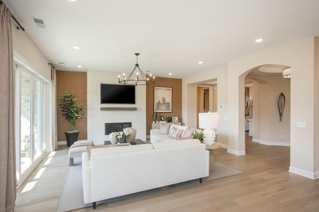 living room with light wood-type flooring, visible vents, baseboards, and recessed lighting