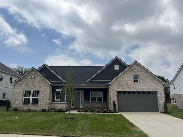 craftsman house with driveway, brick siding, and a front lawn