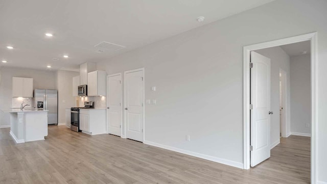 unfurnished living room featuring baseboards, recessed lighting, visible vents, and light wood-type flooring