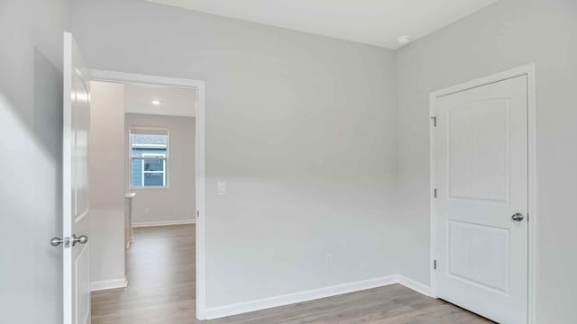 spare room featuring baseboards, recessed lighting, and wood finished floors