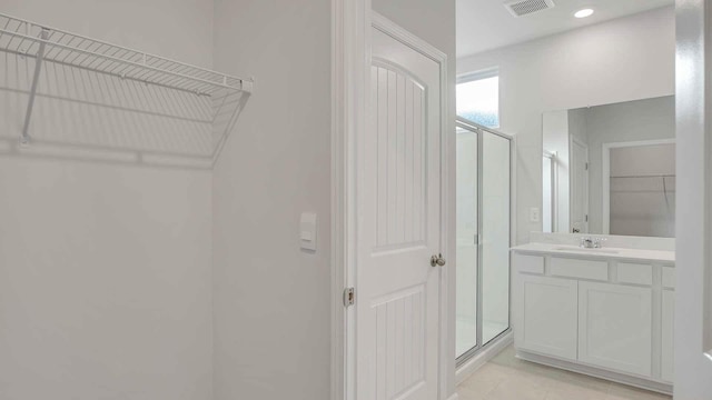 bathroom with a stall shower, vanity, visible vents, and tile patterned flooring