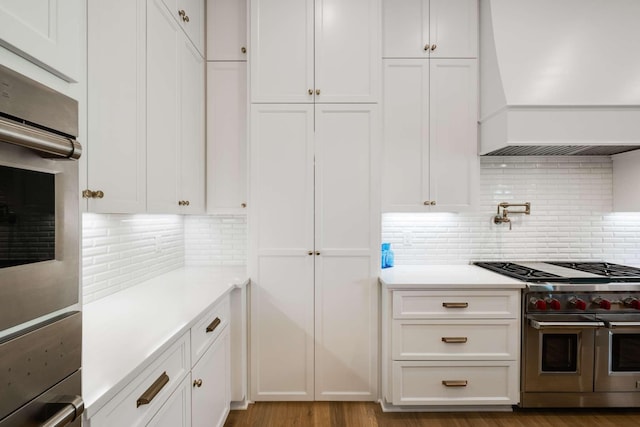 9316 Edenwilde Dr, Brentwood, TN 37027 - kitchen with white cabinets, light countertops, custom range hood, and backsplash