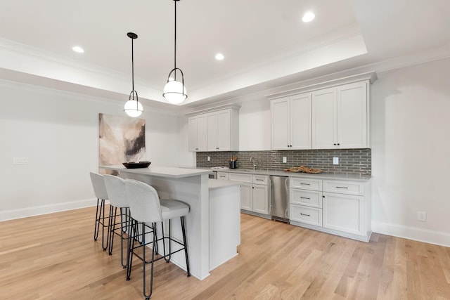9316 Edenwilde Dr, Brentwood, TN 37027 - kitchen featuring a kitchen breakfast bar, light wood finished floors, backsplash, light countertops, and a tray ceiling