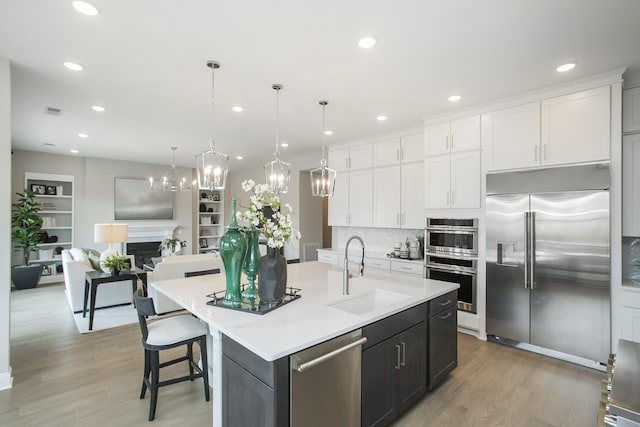 5963 Hunt Valley Dr, Spring Hill, TN 37174 - kitchen featuring stainless steel appliances, a sink, white cabinetry, light wood-style flooring, and light countertops