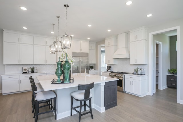 5963 Hunt Valley Dr, Spring Hill, TN 37174 - kitchen with premium appliances, custom range hood, backsplash, a kitchen island with sink, and recessed lighting