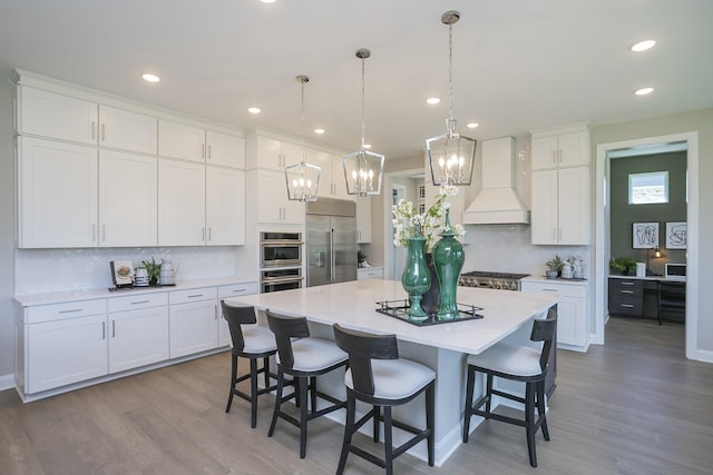 5963 Hunt Valley Dr, Spring Hill, TN 37174 - kitchen with stainless steel appliances, premium range hood, tasteful backsplash, wood finished floors, and recessed lighting