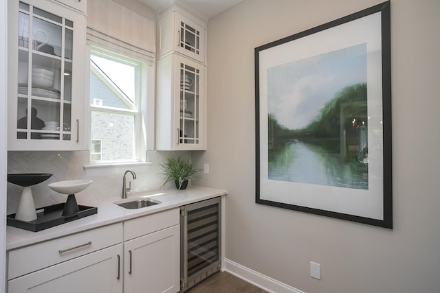 5963 Hunt Valley Dr, Spring Hill, TN 37174 - bar featuring beverage cooler, a sink, backsplash, baseboards, and dark wood-style flooring