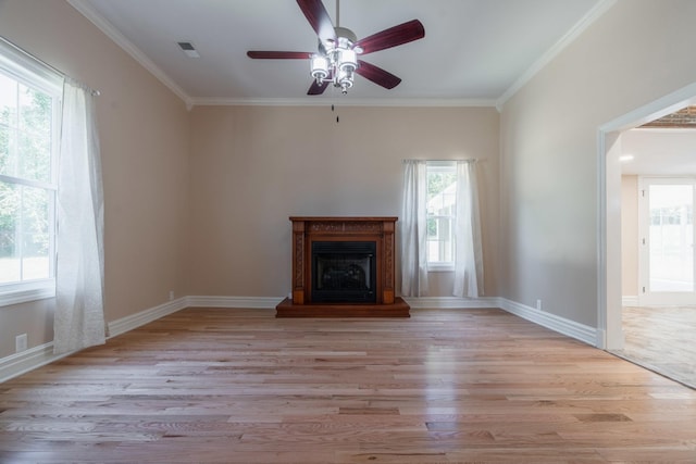 unfurnished living room featuring ornamental molding, light wood-style flooring, a fireplace with raised hearth, and ceiling fan