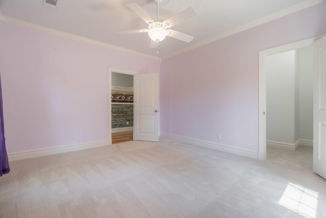 unfurnished bedroom featuring baseboards, a ceiling fan, crown molding, and carpet