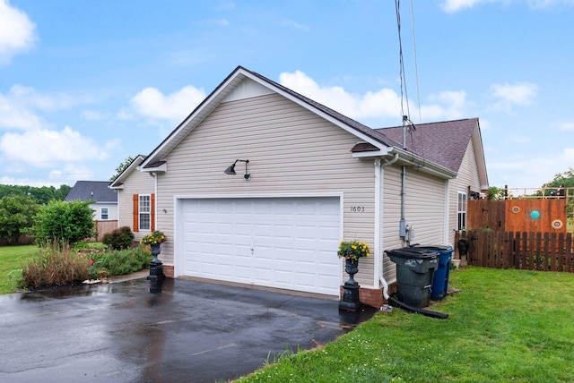 view of property exterior featuring a yard, fence, a garage, and driveway