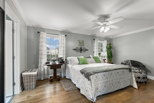 bedroom with baseboards, hardwood / wood-style floors, and crown molding