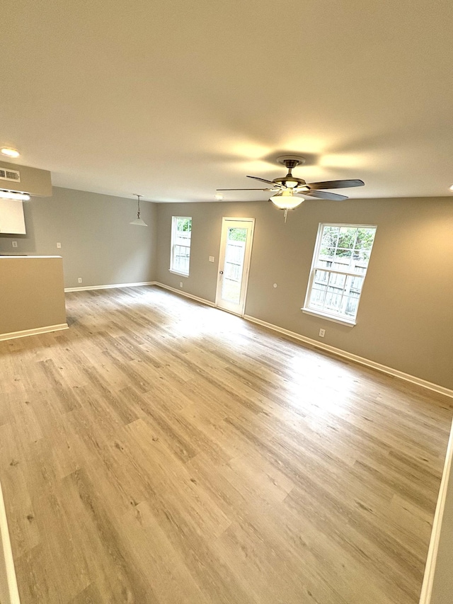 unfurnished room with baseboards, light wood-style flooring, and a ceiling fan