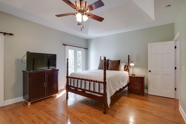 bedroom with light wood-style floors, baseboards, and a ceiling fan