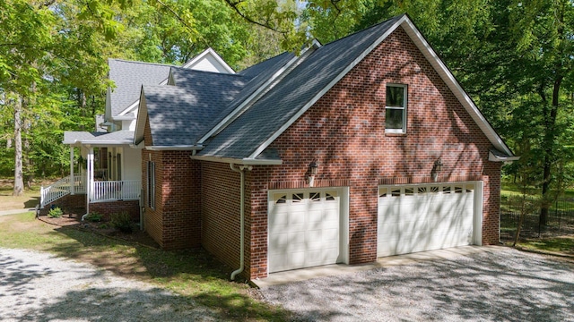view of property exterior with driveway, brick siding, and a shingled roof