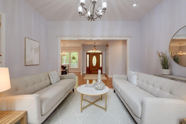 living area with light wood-style flooring, a notable chandelier, and baseboards